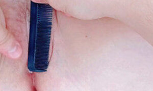 brushing the long hairs of her pussy with a comb inside